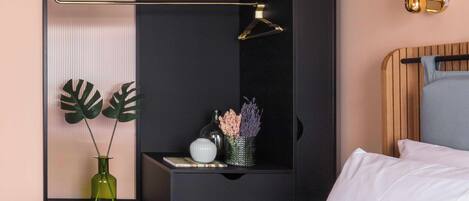 A bedroom with a bed, bedside table, lamp, and decorative items.