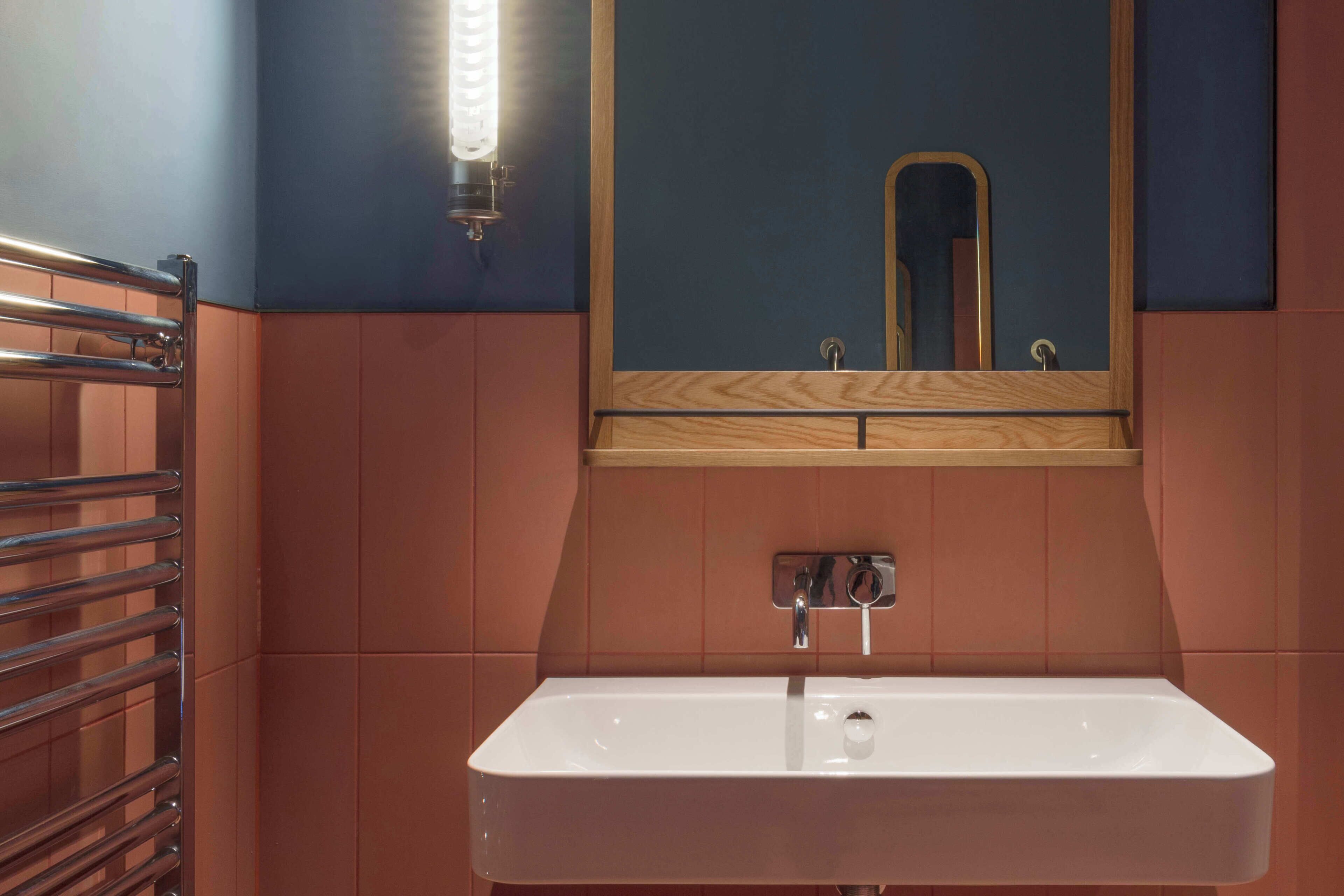 A bathroom with a white sink, a mirror, and a towel rack.