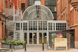 A building with a glass facade, a spiral staircase, and a sign reading 'Whitworth Locke'. - Whitworth Locke (Manchester)