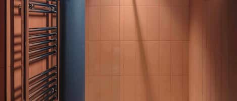 Une salle de bain avec un porte-serviettes, des murs carrelés et une baignoire.