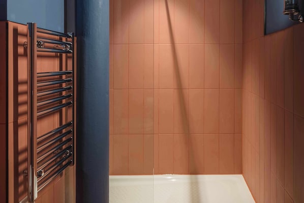 A bathroom with a towel rack, tiled walls, and a bathtub.