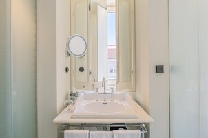 A bathroom with a white sink, a mirror, and a towel rack.