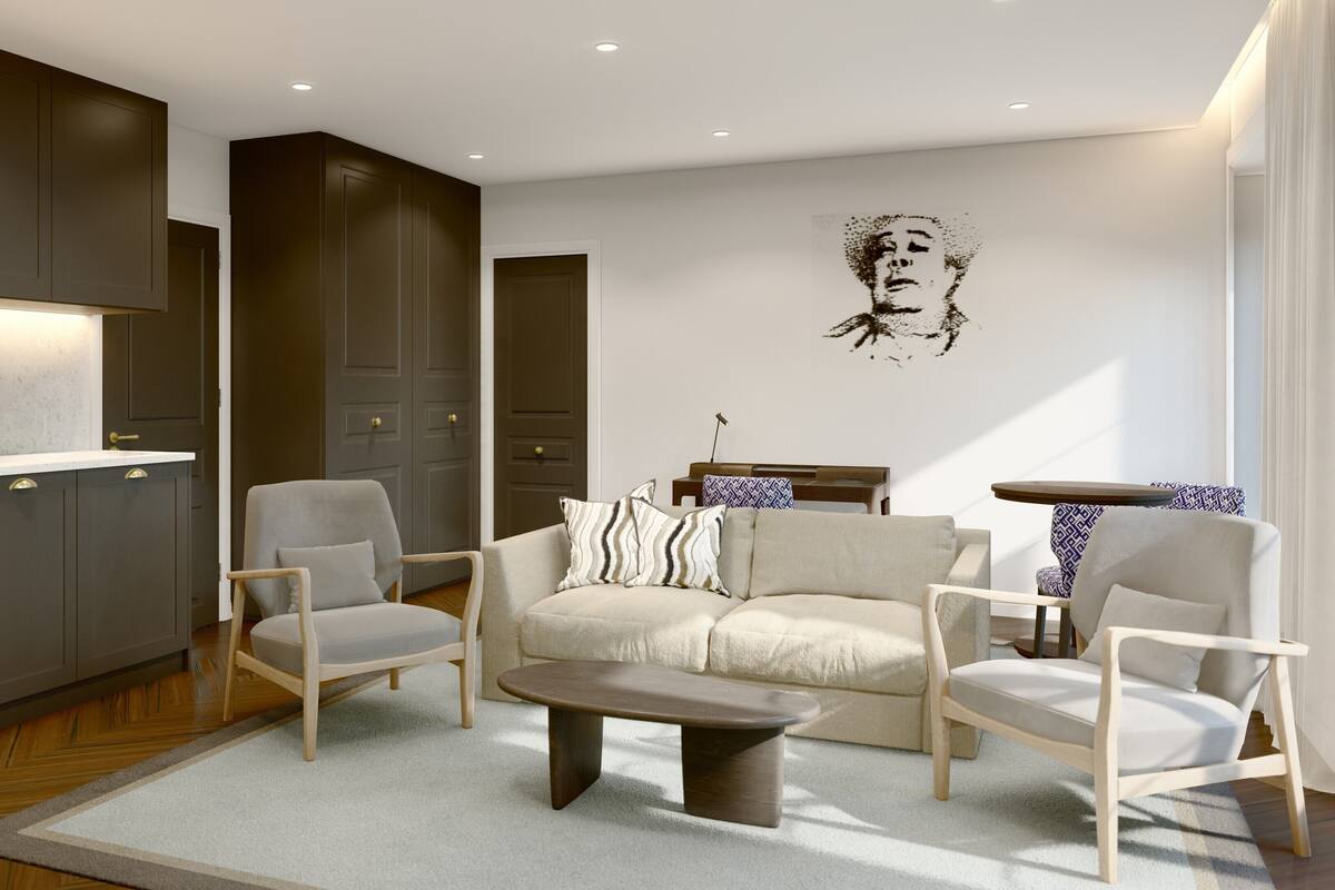 A modern living room with a sofa, chairs, a coffee table, and a kitchen area with cabinets and a countertop.