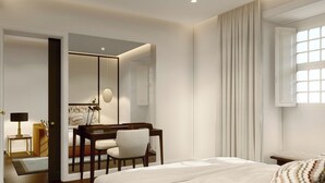 Quarto de hotel com cama, escrivaninha, cadeira, espelho e janela com cortinas.