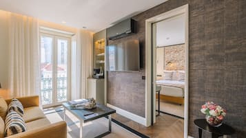 A modern living room with a sofa, coffee table, and a view of the city through large windows.