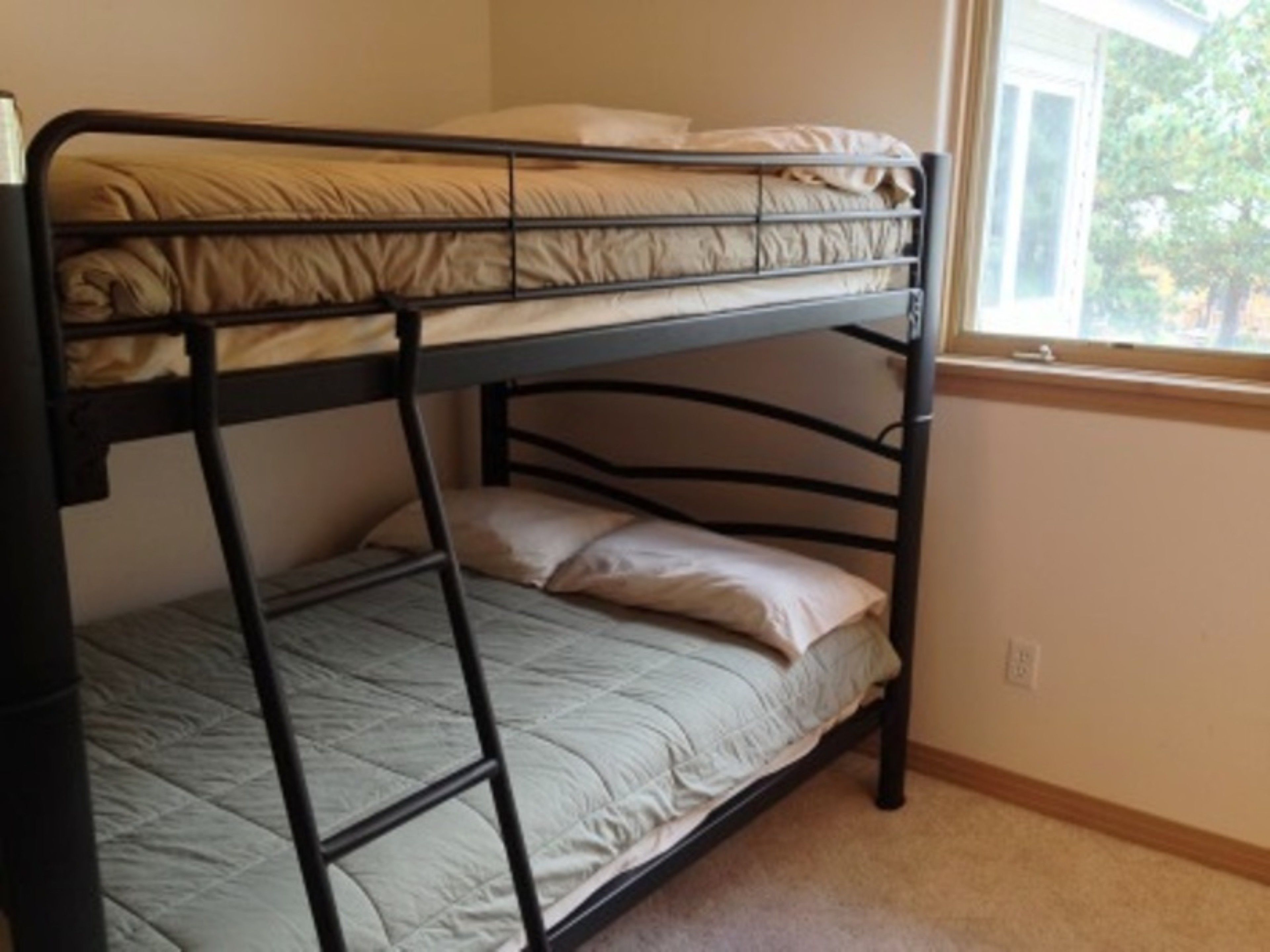 A bunk bed with a window above it.