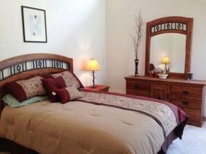 A bedroom with a bed, a dresser, two lamps, and a mirror. - Mountain Haven (Angel Fire)