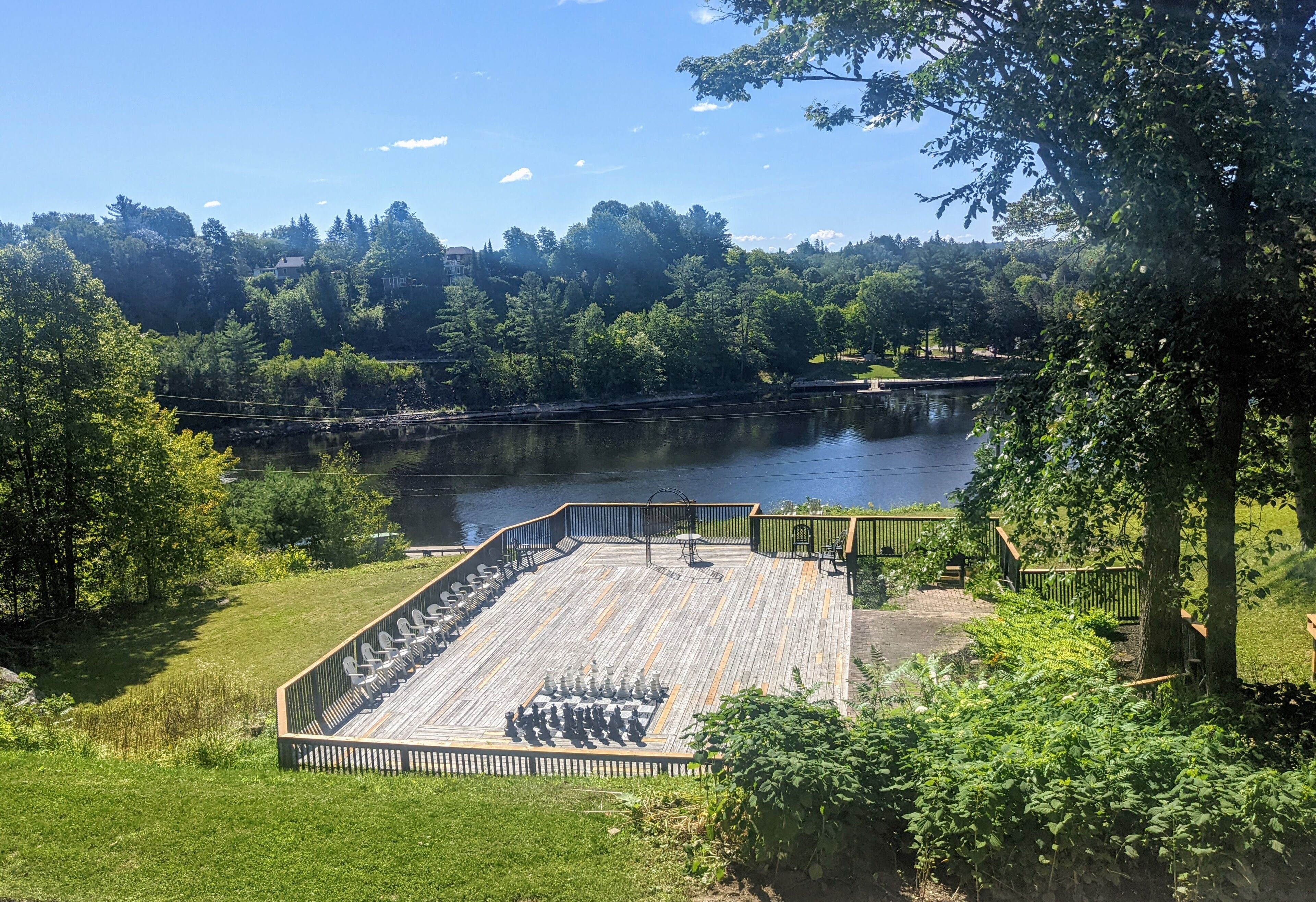 A lakeside deck with seating and a view of the lake.