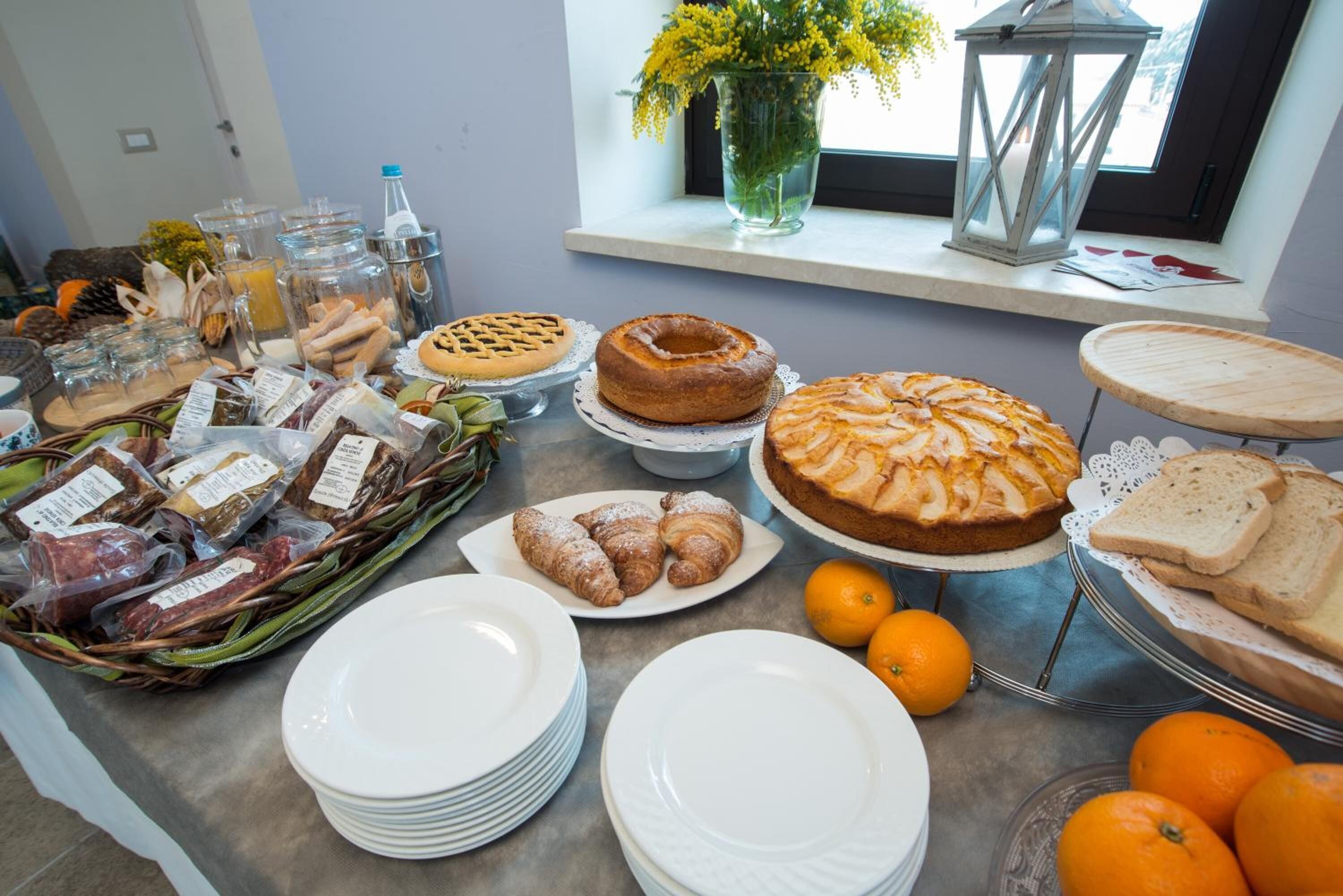 Un bufé de desayuno con panes, pasteles y frutas variados.