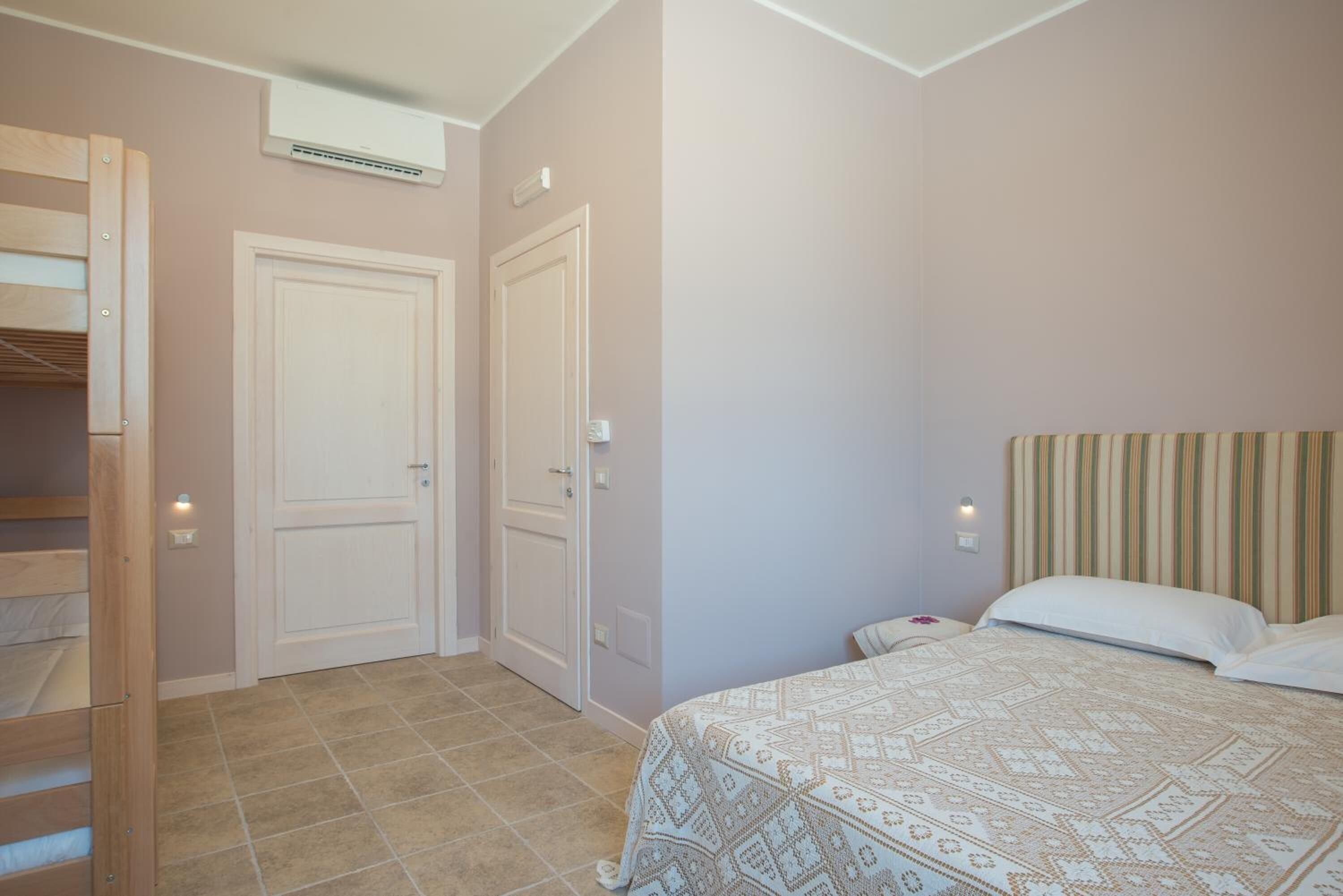 A bedroom with a bed, a wardrobe, and a door.