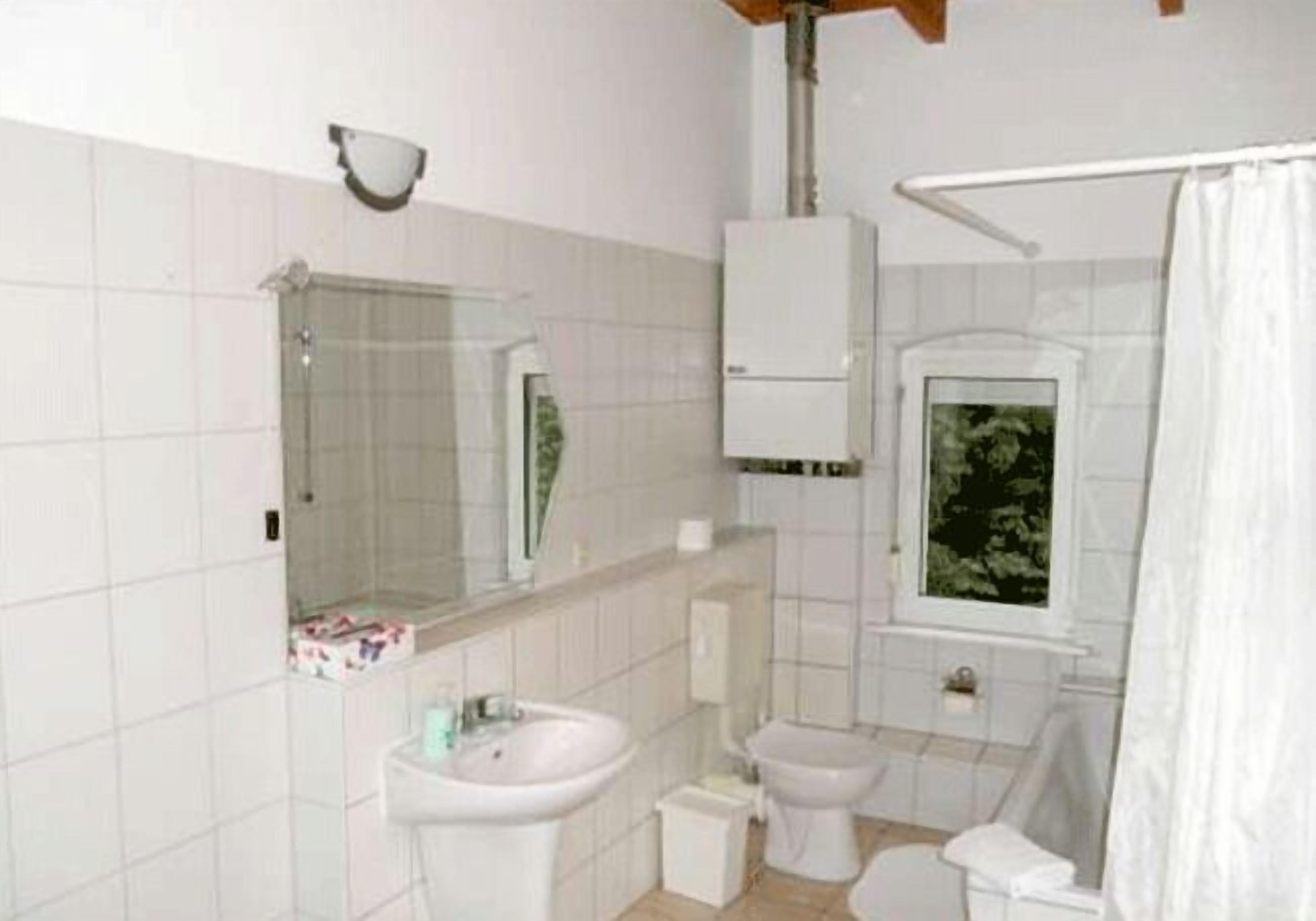 A bathroom with a sink, toilet, and shower.