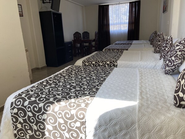 A hotel room with two beds, a desk, and a chair. - Hotel Royal Puebla (Puebla)