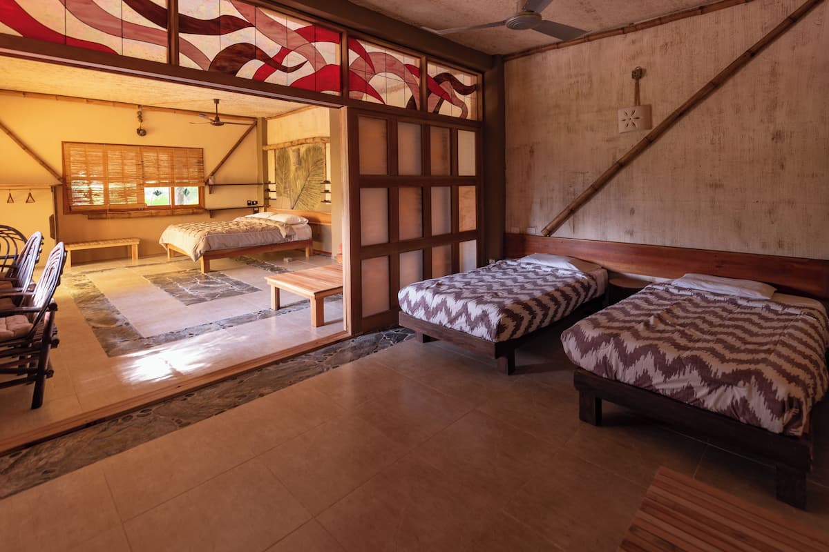 A traditional Japanese-style bedroom with two beds, a sliding door, and a tatami mat floor.
