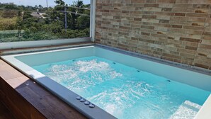 A hot tub with a view of a brick wall and greenery outside. - KSL Residence (Boca Chica)