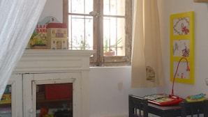 Una habitación con ventana, una mesa pequeña y una silla.