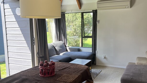 Una habitación acogedora con una mesa de madera, un banco y un sofá.