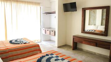 Habitación de hotel con dos camas, televisión, espejo y armario.
