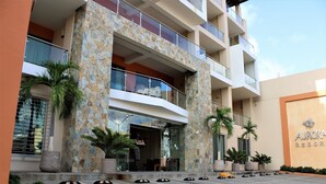 Un hotel de varios pisos con fachada de piedra, balcones y un letrero que dice 'AURORA RESORT'.