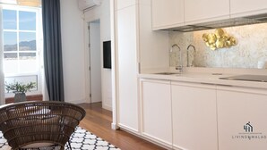 A modern kitchen with white cabinets, a stainless steel sink, and a decorative backsplash. - Atico MarinaLiving4malaga (Málaga)
