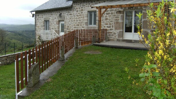 A stone house with a wooden deck and a view of the countryside. - stone house Saint Léger de Peyre (Saint-Léger-De-Peyre)
