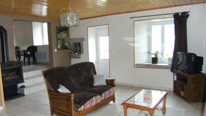 A living room with a wooden sofa, a glass coffee table, a television, and a potted plant by the window. - stone house Saint Léger de Peyre (Saint-Léger-De-Peyre)