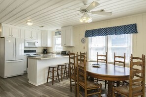 Enjoy meals in the well-equipped kitchen and dining area with microwave, stove, and comfortable seating.