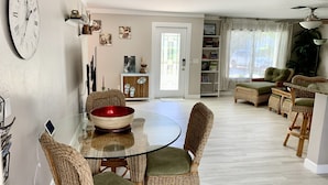 A dining area with wicker chairs, a glass table, and a red bowl. - Vacation Home 6 minutes to the beach, heated pool, free canoe, free wifi  (Bonita Springs)