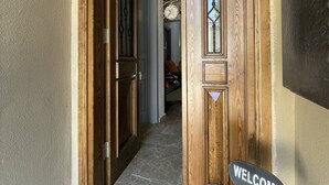 Une porte en bois ornée d’une pancarte « Bienvenue », d’une horloge et d’une décoration représentant un chat.