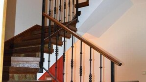 A staircase with wooden steps and black balusters, leading to an upper floor. - Hotel Los Robles (Cangas de Onis)