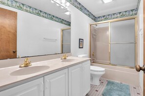 Un baño con dos lavamanos, un inodoro y una bañera.
