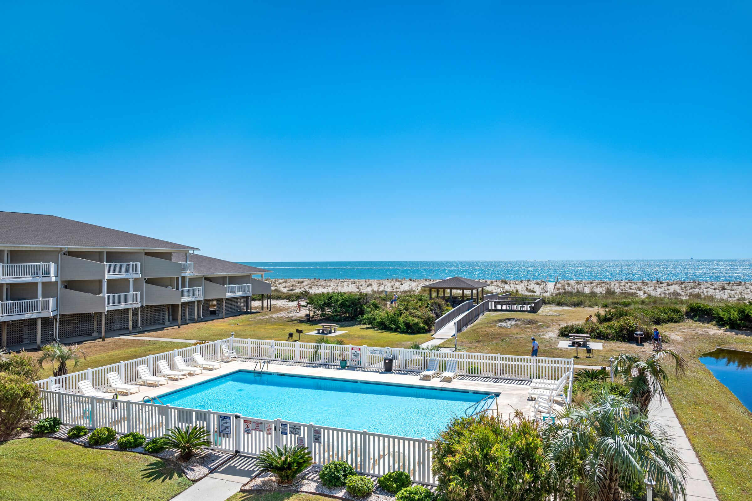 Una piscina con lettini, un solarium e vista sull'oceano.