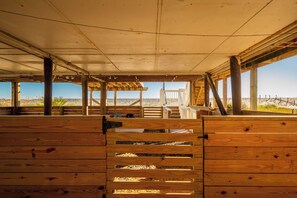 An indoor wooden structure with a view of the beach. - On Turtle Time: Modern Oceanfront Home Ideal for Two Couples or Small Families (Oak Island)