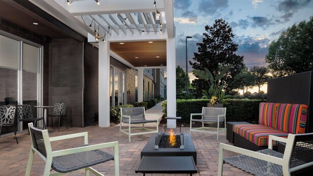 Une terrasse extérieure avec des sièges, un foyer et une vue sur le ciel.