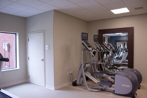 A gym with multiple treadmills and exercise equipment, a door, and a window with a view of a brick building. - Hampton Inn & Suites Cranberry Pittsburgh (Cranberry Township)