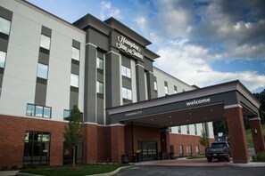 A Hampton Inn & Suites building with a clear entrance, a welcome sign, and a parking area with a truck. - Hampton Inn & Suites Cranberry Pittsburgh (Cranberry Township)