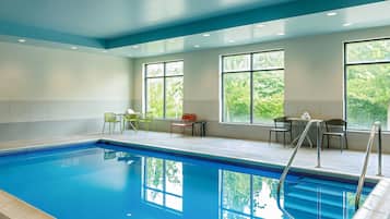 A swimming pool with a clear view of the surrounding area, including a seating area with chairs and a table.