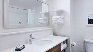A bathroom with a white sink, a mirror, a towel rack, and a toilet.