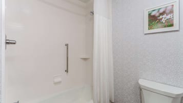 Une salle de bain avec une baignoire, des toilettes et un rideau de douche.