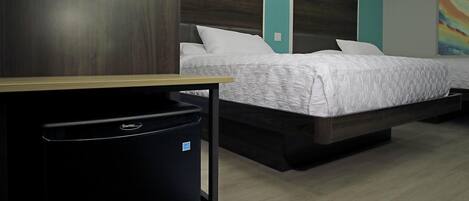 A modern hotel room with a bed, a desk, and a trash bin.