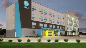 Un hotel moderno con un llamativo letrero 'tru Hilton', múltiples accesos y un exterior bien cuidado.