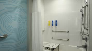 Un baño moderno con ducha, barras de apoyo y un perchero para toallas.