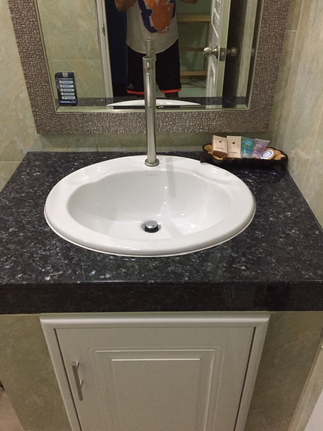 A bathroom with a white sink, a mirror, and a cabinet.