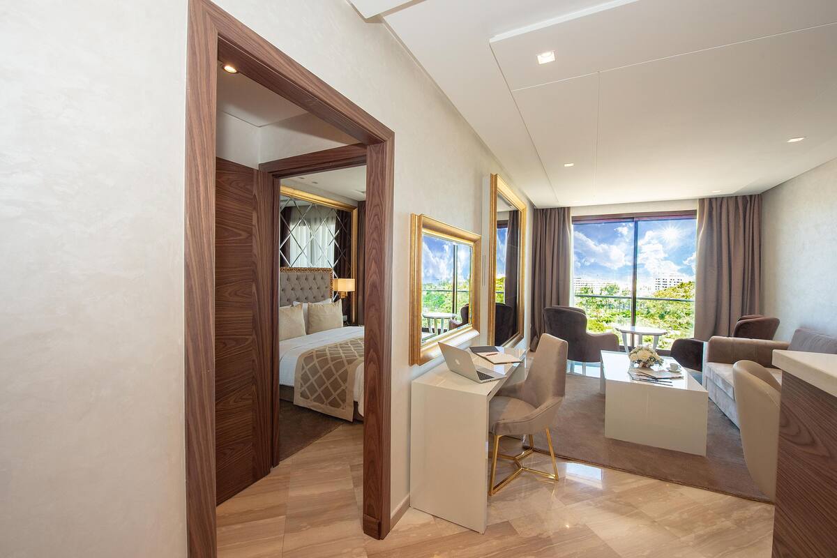 Ein modernes Hotelzimmer mit Bett, Schreibtisch und Sitzecke.