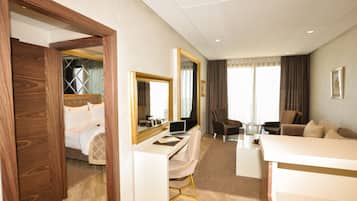 Une chambre d’hôtel avec un lit, un bureau avec un ordinateur portable, une chaise, un canapé et un grand miroir.