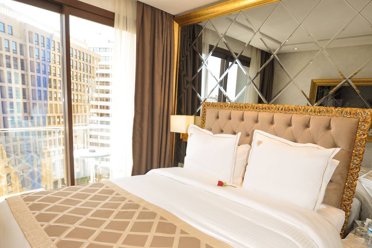 Ein Hotelzimmer mit großem Bett, Blick auf die Stadt und modernem Design.