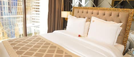 A hotel room with a large bed, a view of the city, and a modern design.