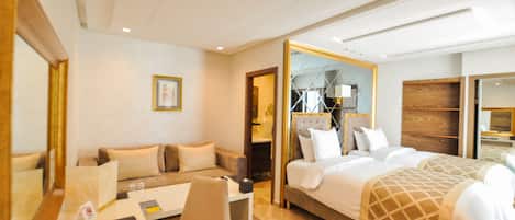 Una habitación de hotel con una cama, un sofá, un escritorio y un espejo.