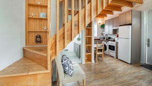 A wooden staircase leading to a living area with a sofa and a coffee table. - Sea Breeze Cottages (Ocean Shores)