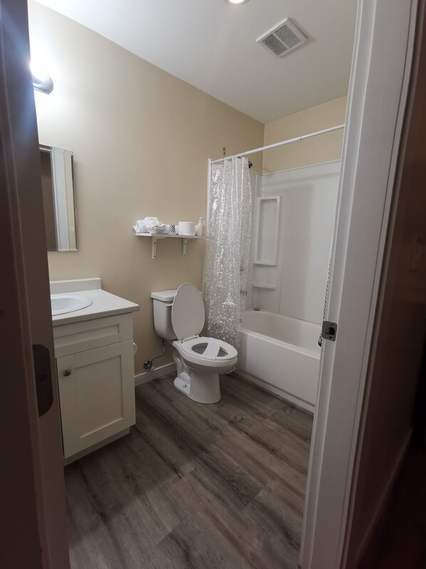 A bathroom with a toilet, sink, and bathtub. - Coquihalla Motel (Hope)