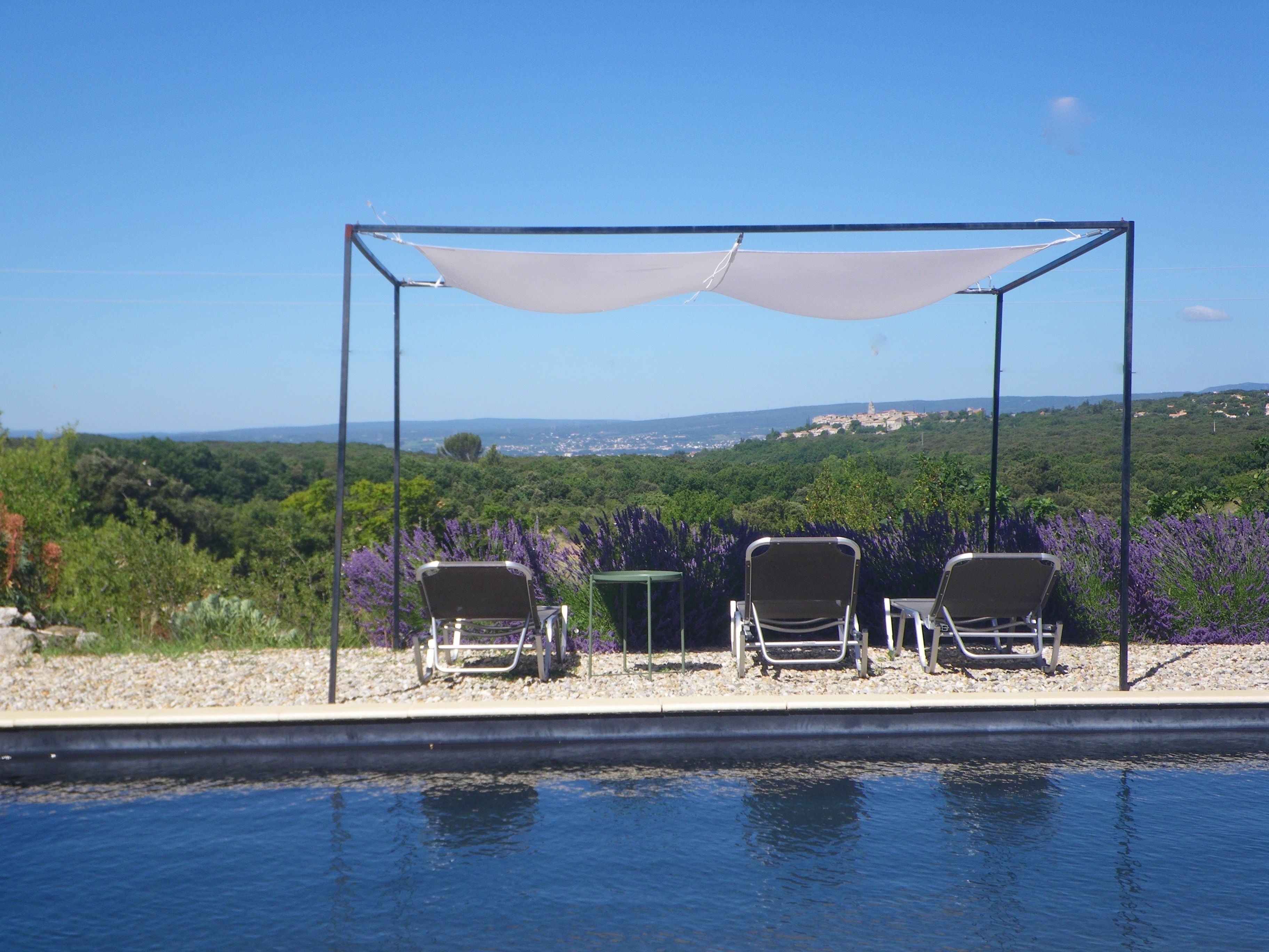 Una piscina al aire libre, sillones reclinables de piscina